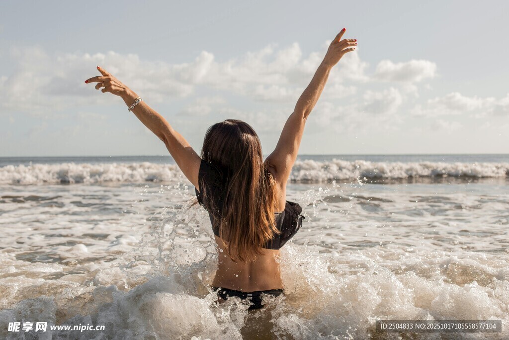 海边女子舒展双臂迎海浪
