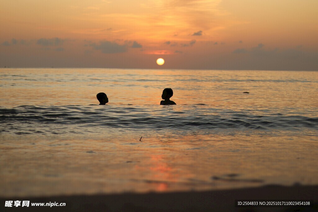 夕阳下海中两人的美好画面