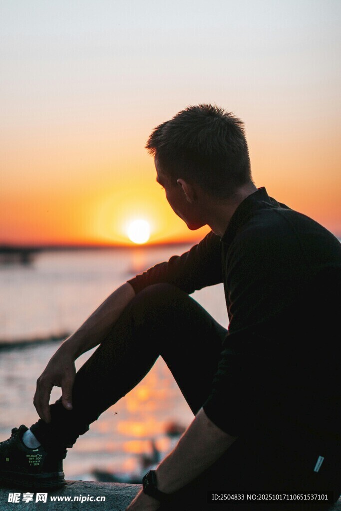 夕阳下独坐海边的男子