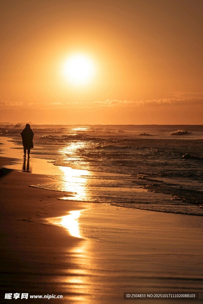 夕阳下的海边漫步身影