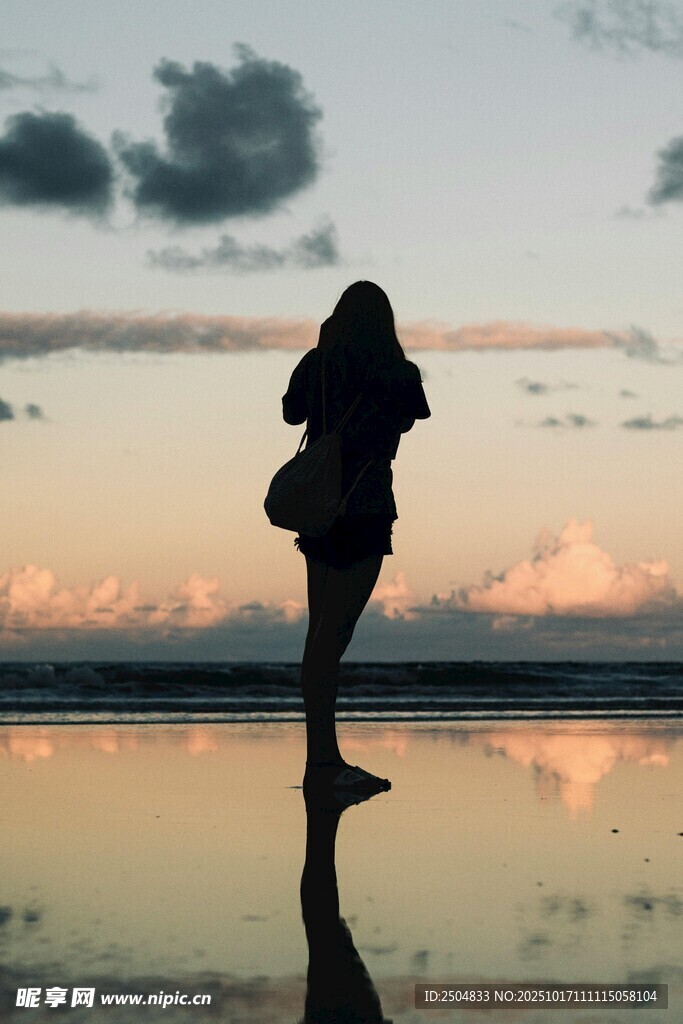 夕阳下海边女子的曼妙剪影