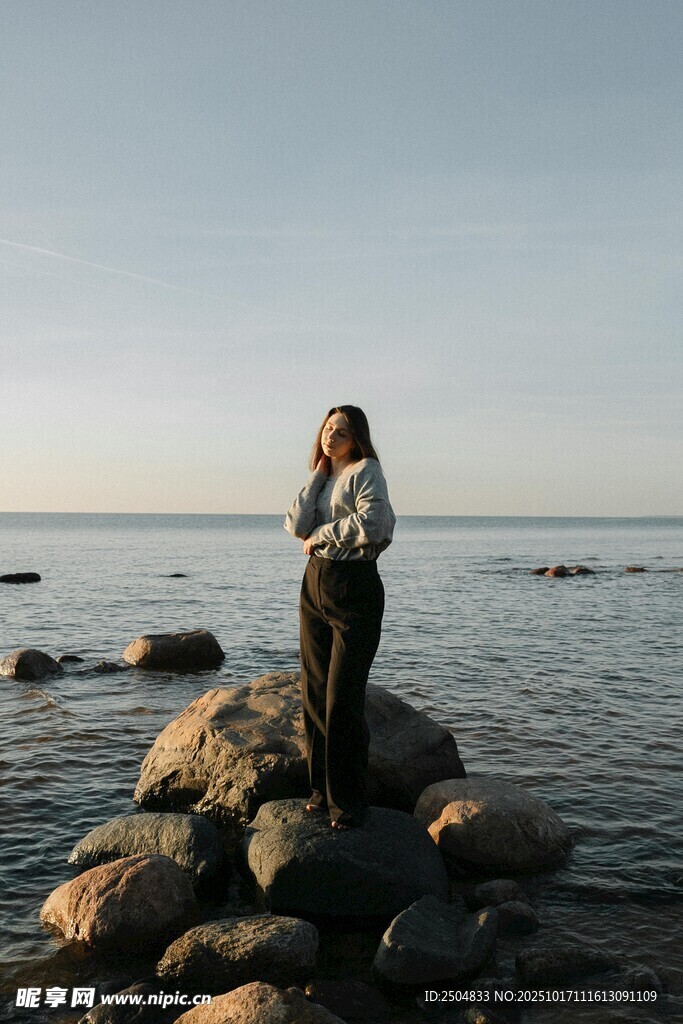 女子立于海边礁石赏景