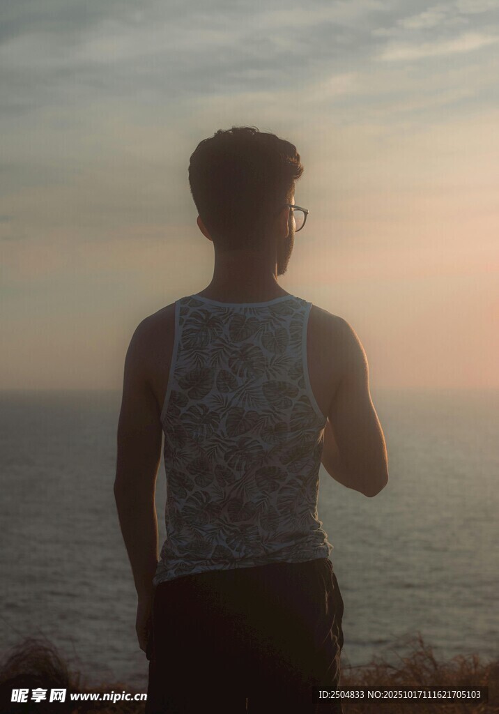 海边男子逆光而立赏景