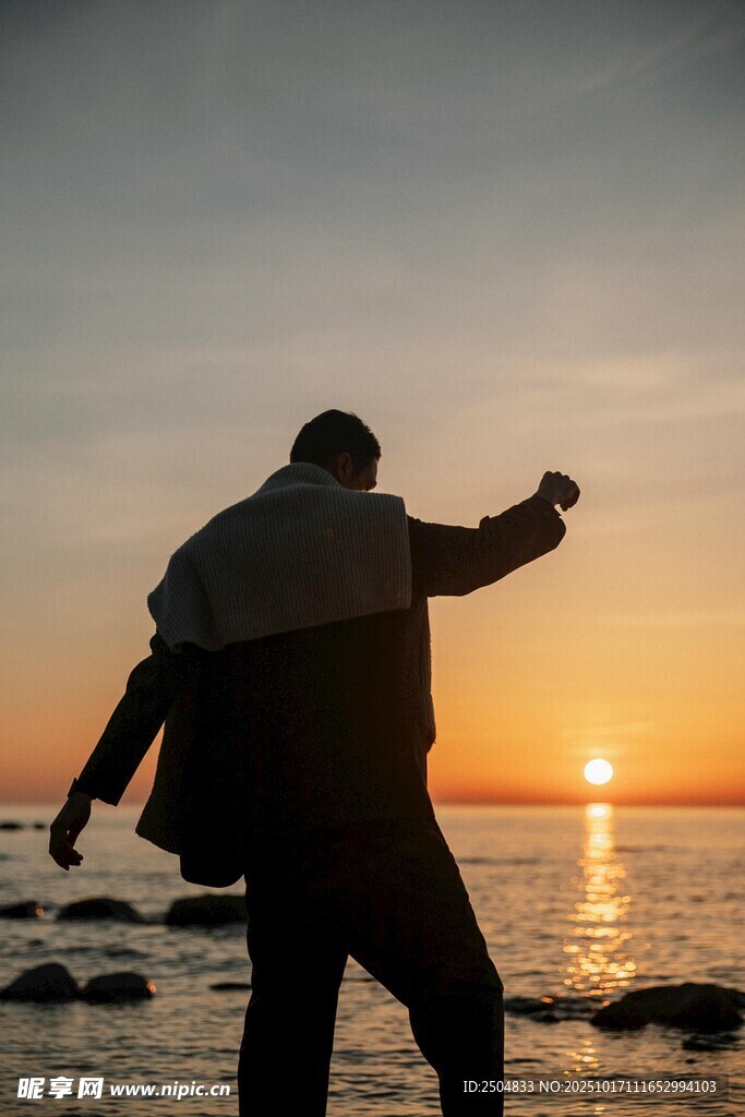 夕阳下海边的潇洒背影