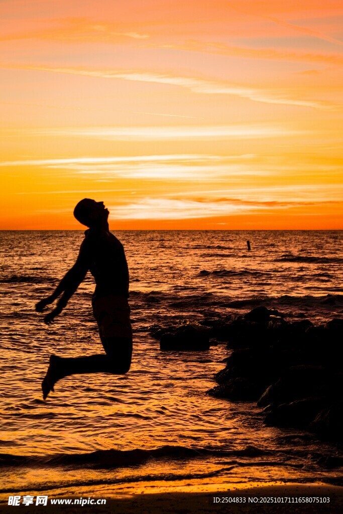 夕阳下海边跳跃的身影