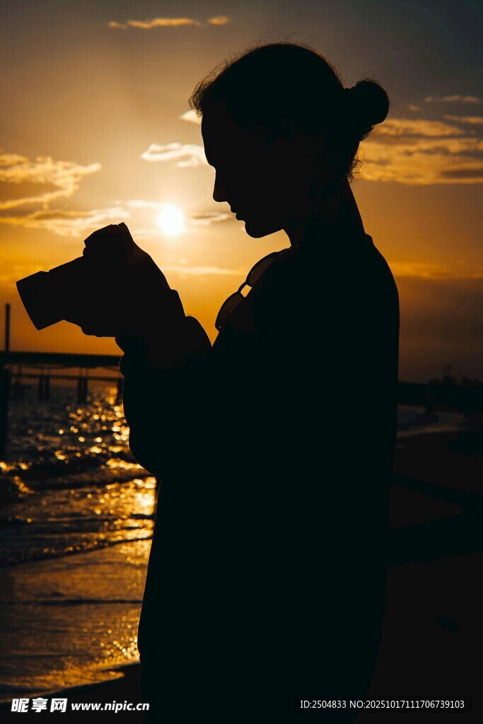 海边夕阳下的摄影者剪影