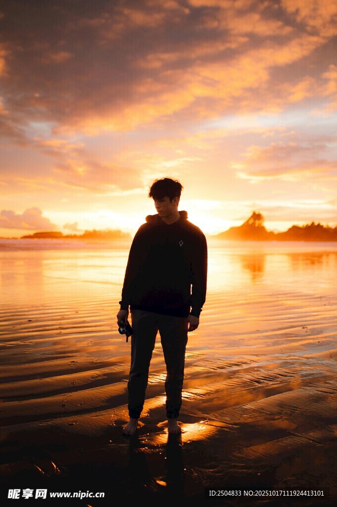 夕阳下立于水边的孤独身影