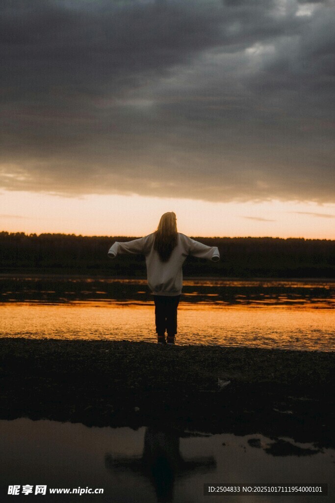 夕阳下的独行者张开双臂