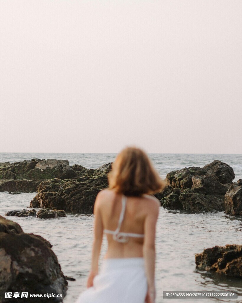 海边漫步的优雅女子