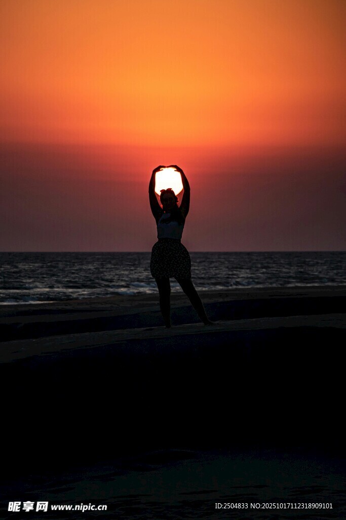 夕阳下的海边瑜伽者