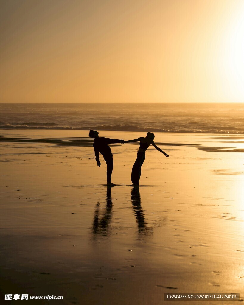 夕阳下海滩上的两人剪影