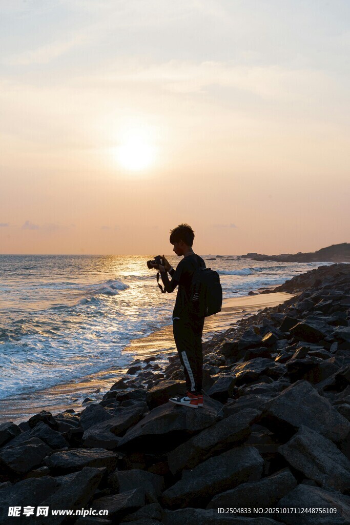 夕阳下海边的孤独摄影者