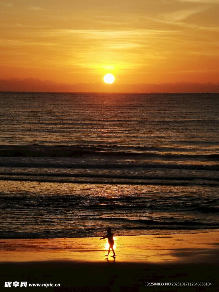 夕阳下海滩上的孤独身影