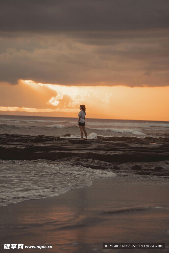 夕阳下海滩上的孤独身影