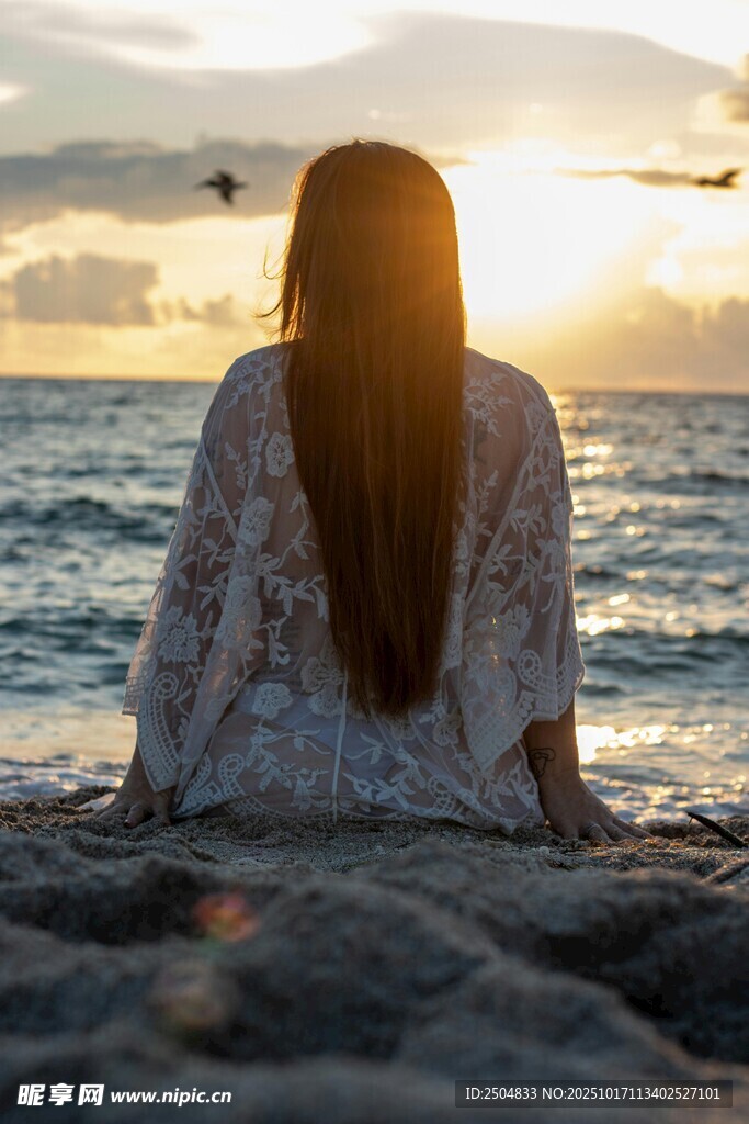 海边女子赏日落背影