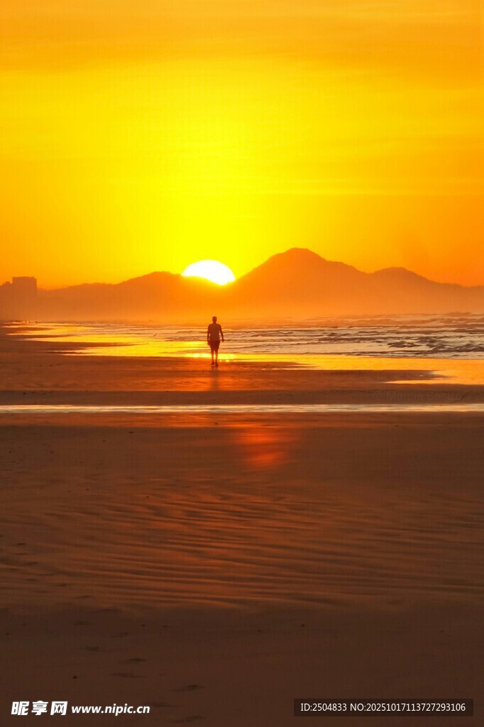 夕阳下海滩上的孤独身影