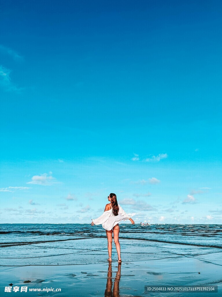 海边女子于蓝天碧海间伫立