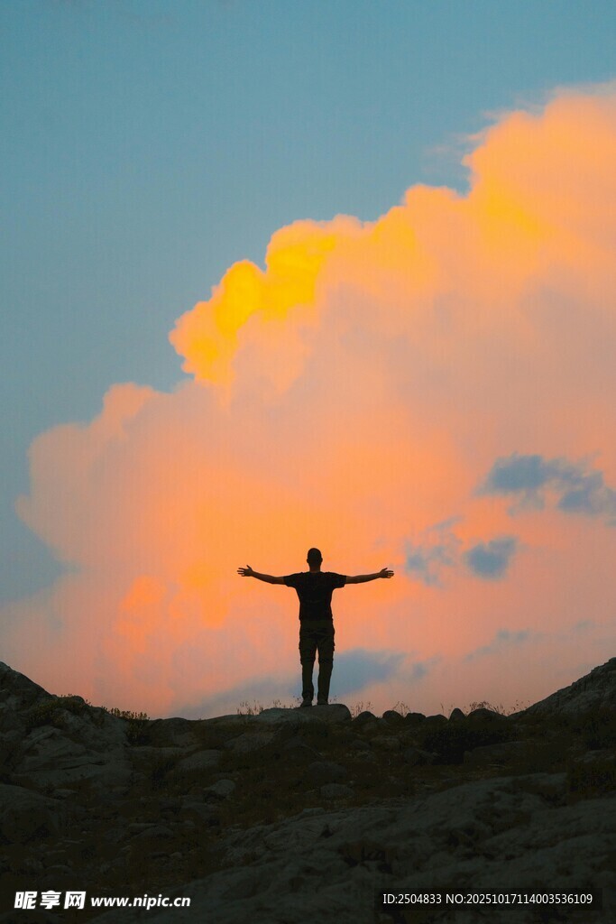 夕阳下张开双臂的孤独身影