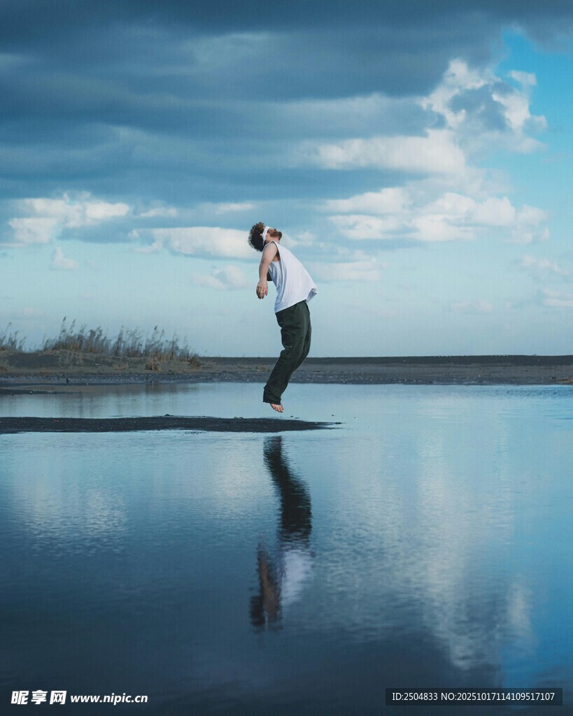 男子于平静湖面起舞