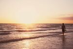 夕阳下漫步海滩的身影