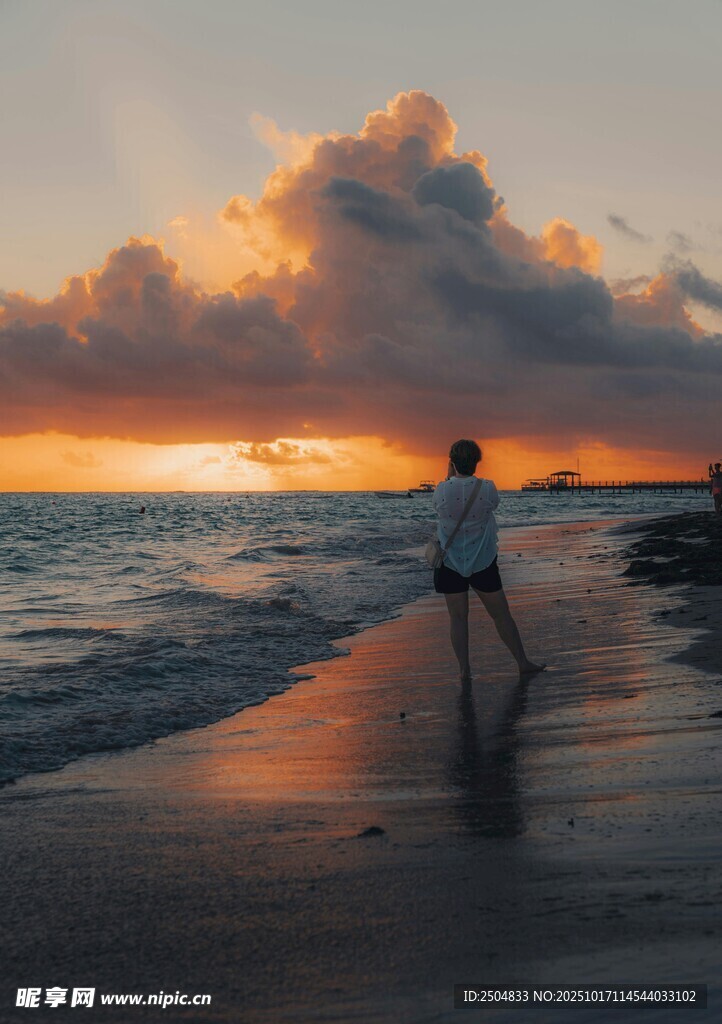 夕阳下漫步海滩的身影