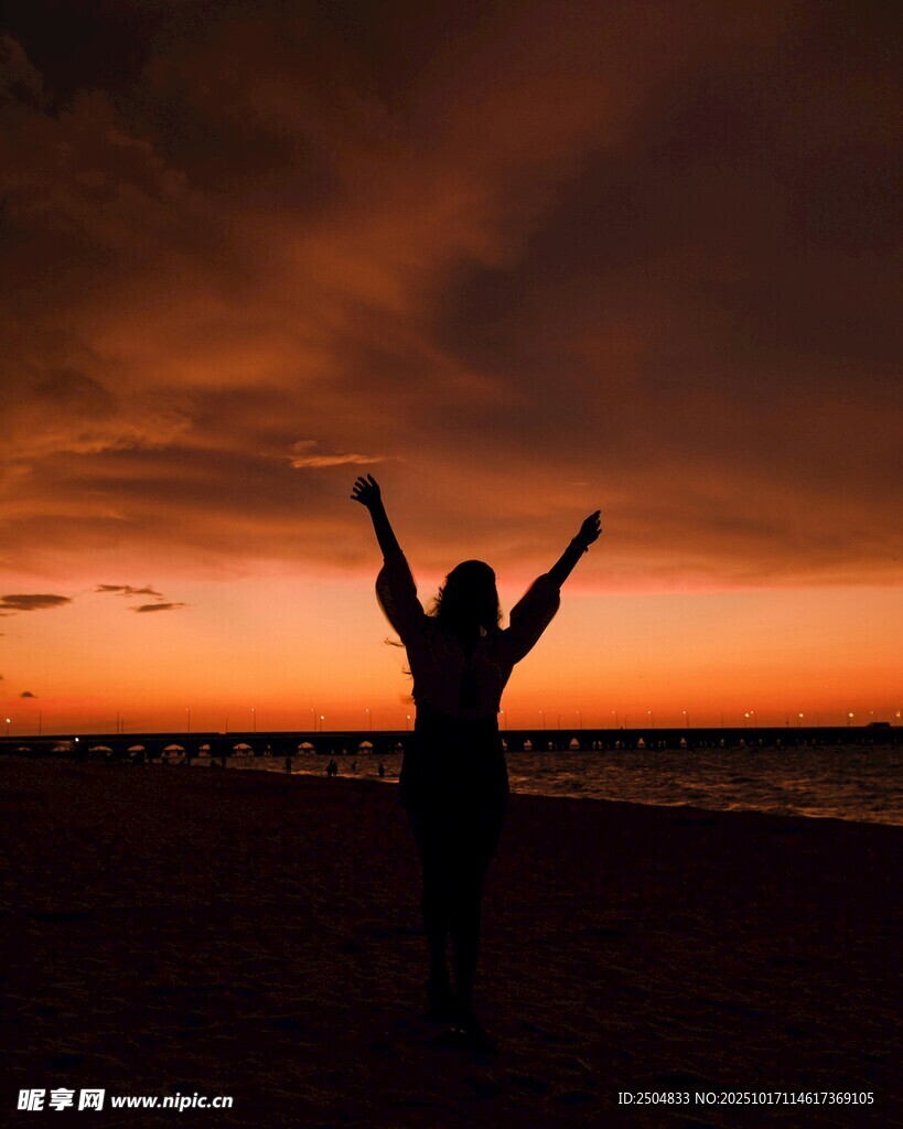夕阳下的海边欢呼身影
