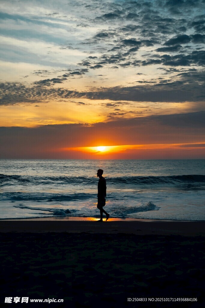 夕阳下海滩上的孤独身影