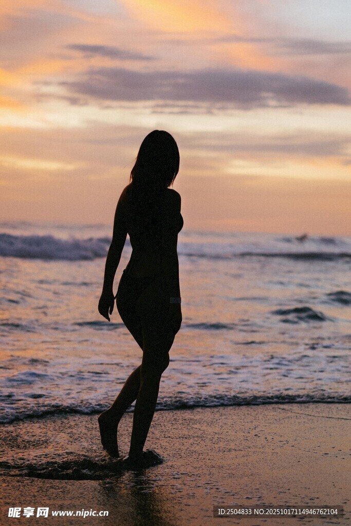 海边漫步的女子剪影