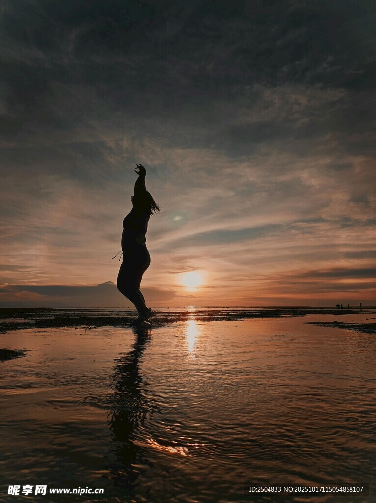 夕阳下海边起舞的曼妙身影