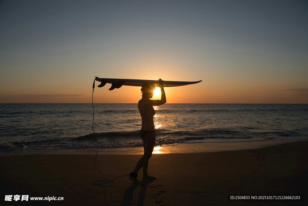 夕阳下海滩上的冲浪者
