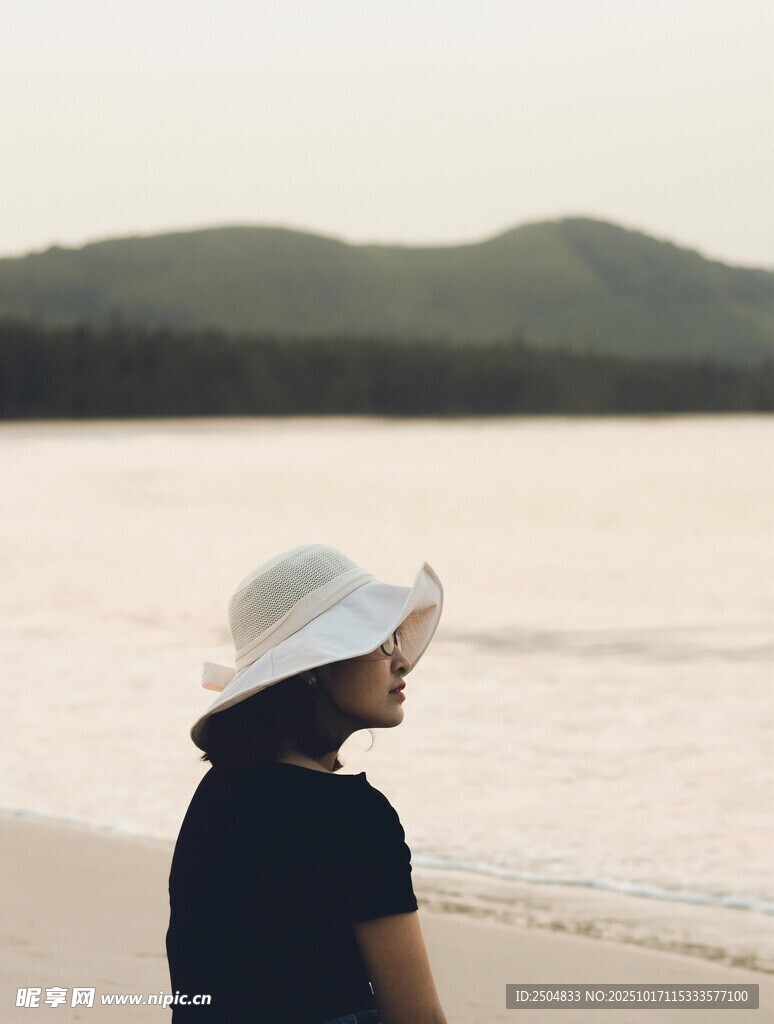海边戴帽女子的静谧时刻
