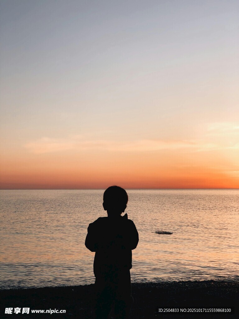 夕阳下海边孩童的背影