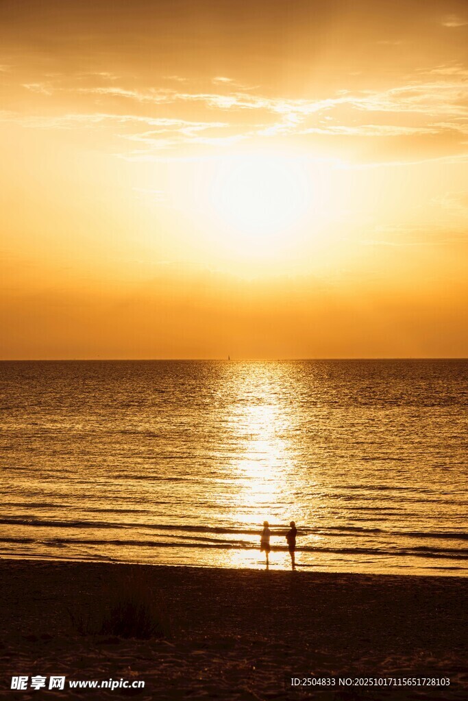 夕阳下海边漫步的两人