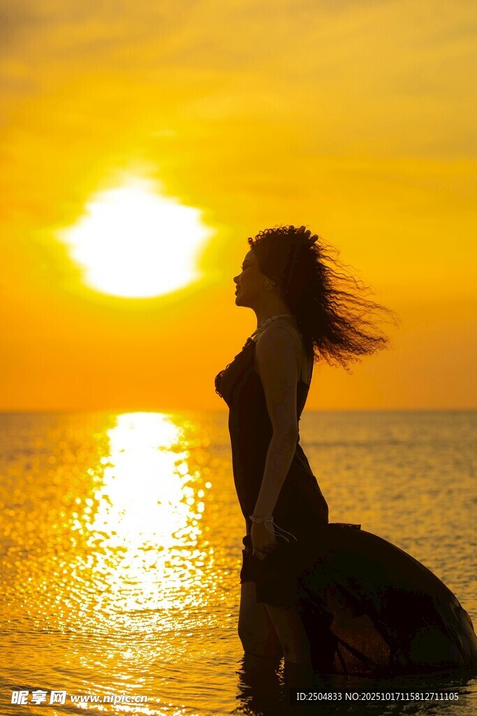 夕阳下海边的飘逸女子