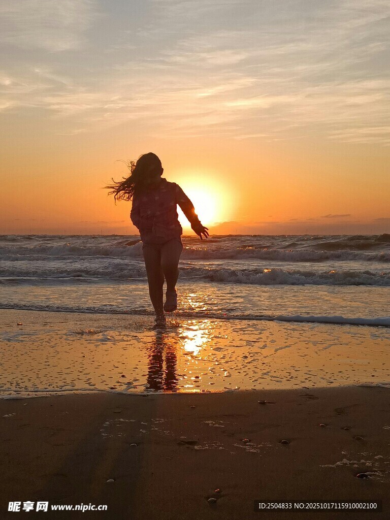 夕阳下海边漫步的女子