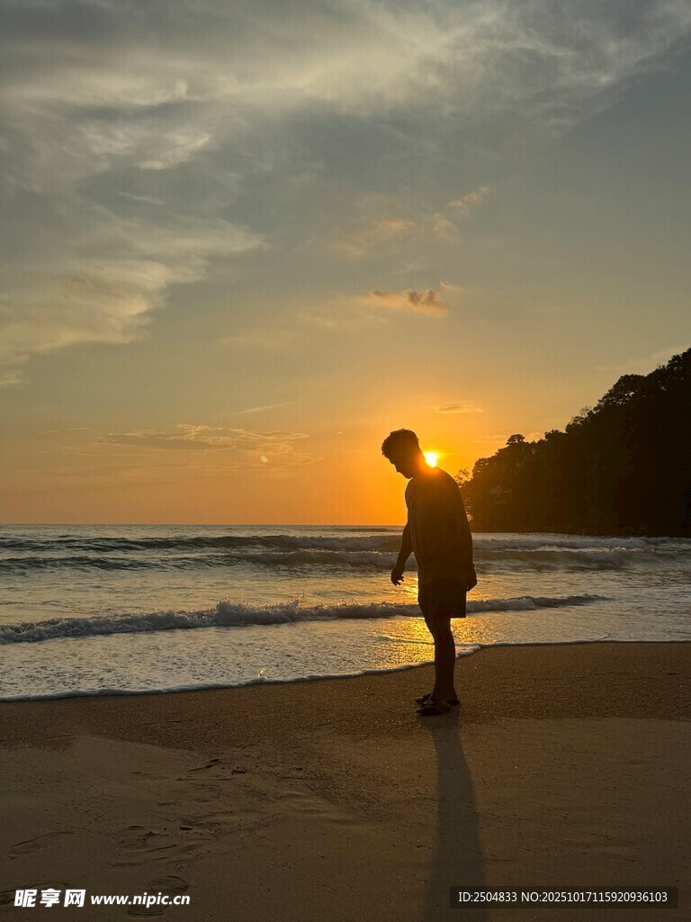 夕阳下海滩上的孤独身影