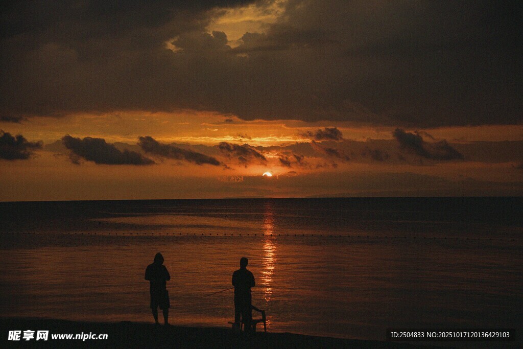 夕阳下海边的两人身影