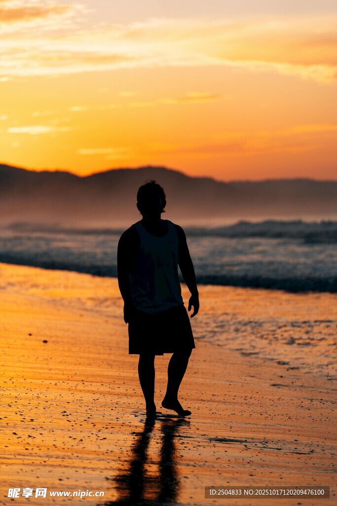 夕阳下漫步海滩的身影