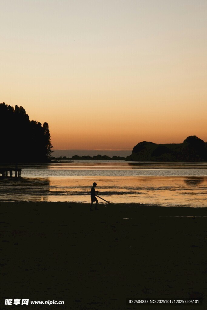 夕阳下的海滩漫步身影