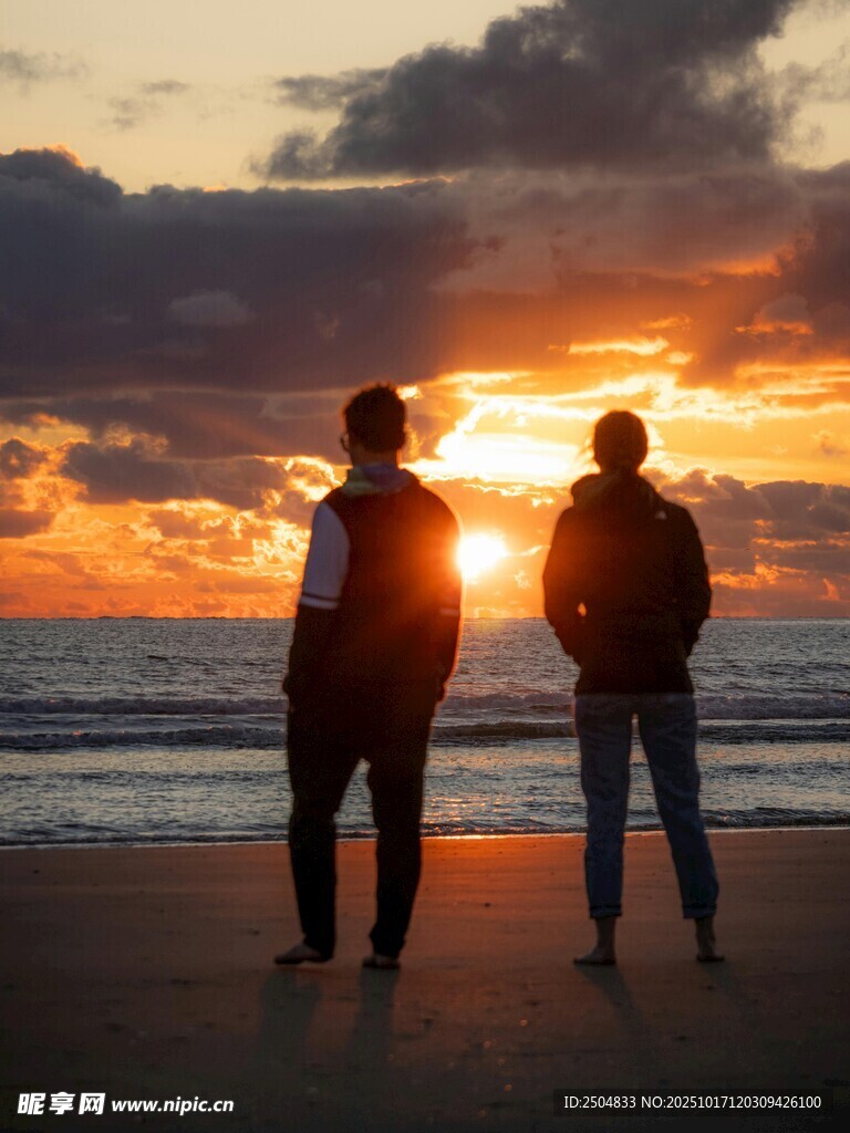 夕阳下海边的两人背影