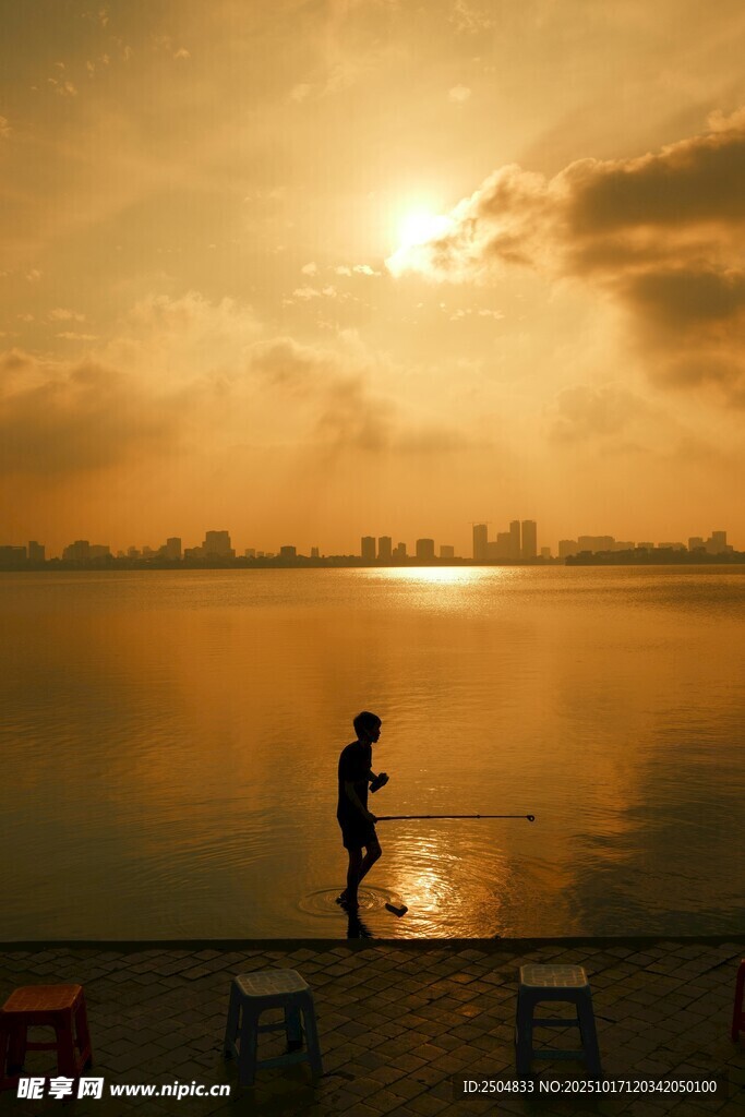 夕阳下的湖畔垂钓者