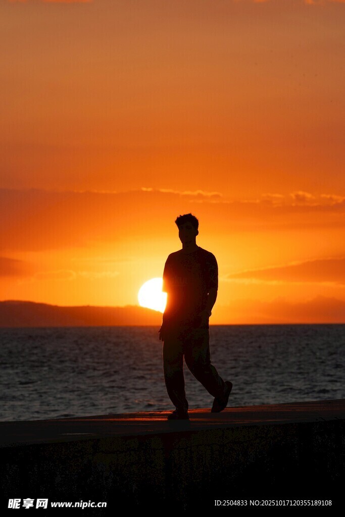 夕阳下海边漫步的身影