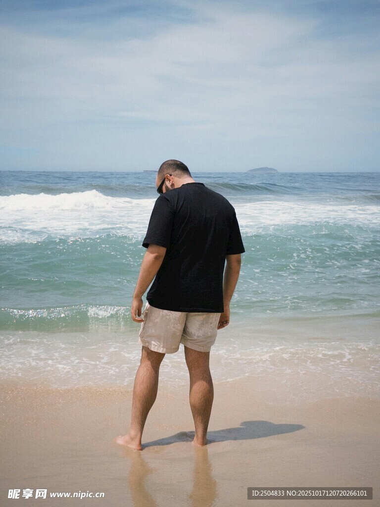 男子独自漫步在海边沙滩
