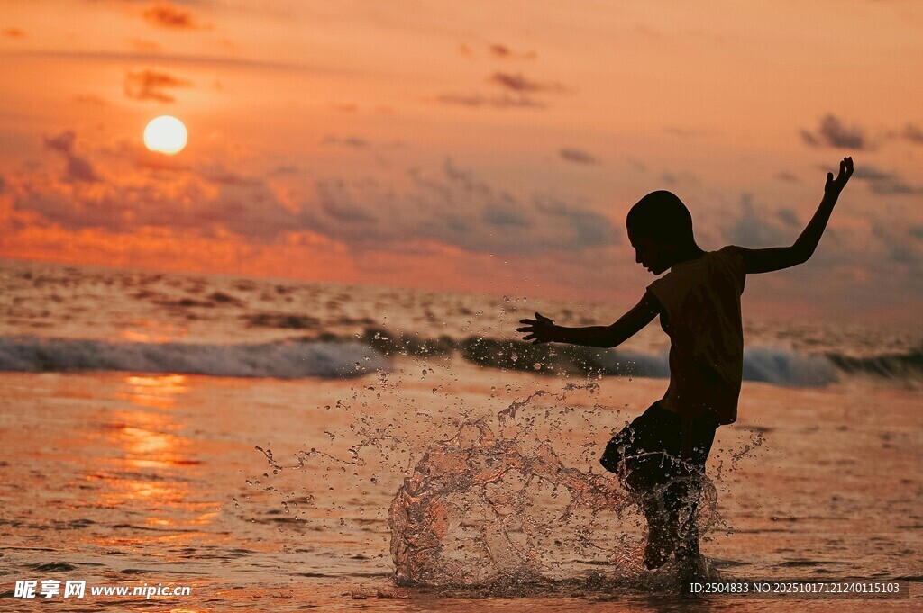 夕阳下海边嬉戏的少年