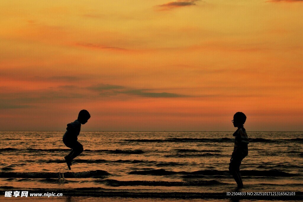 夕阳下海边的两人剪影
