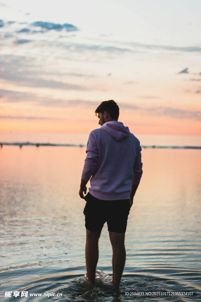 男子伫立水边赏日落美景