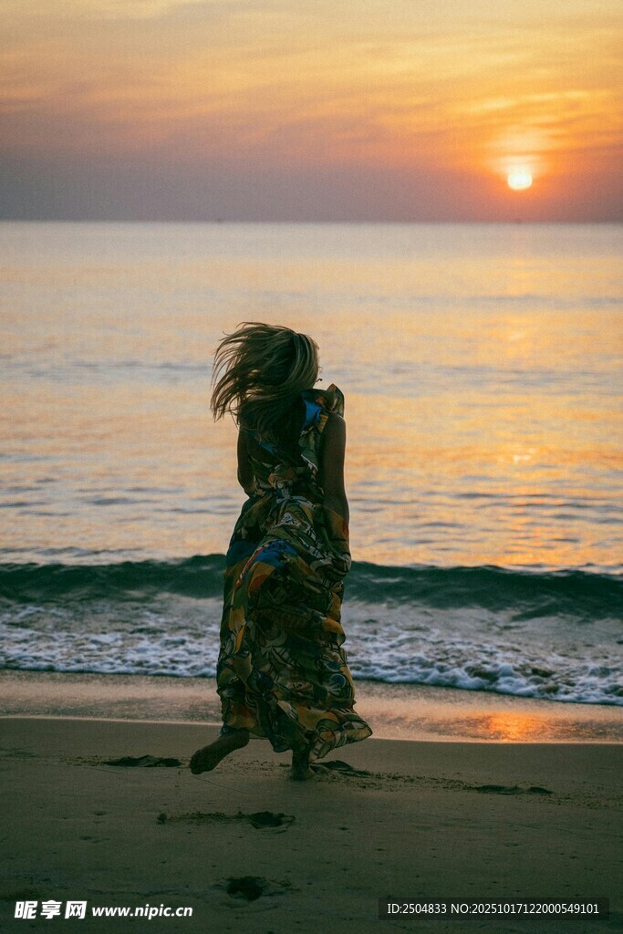 夕阳下海边漫步的女子