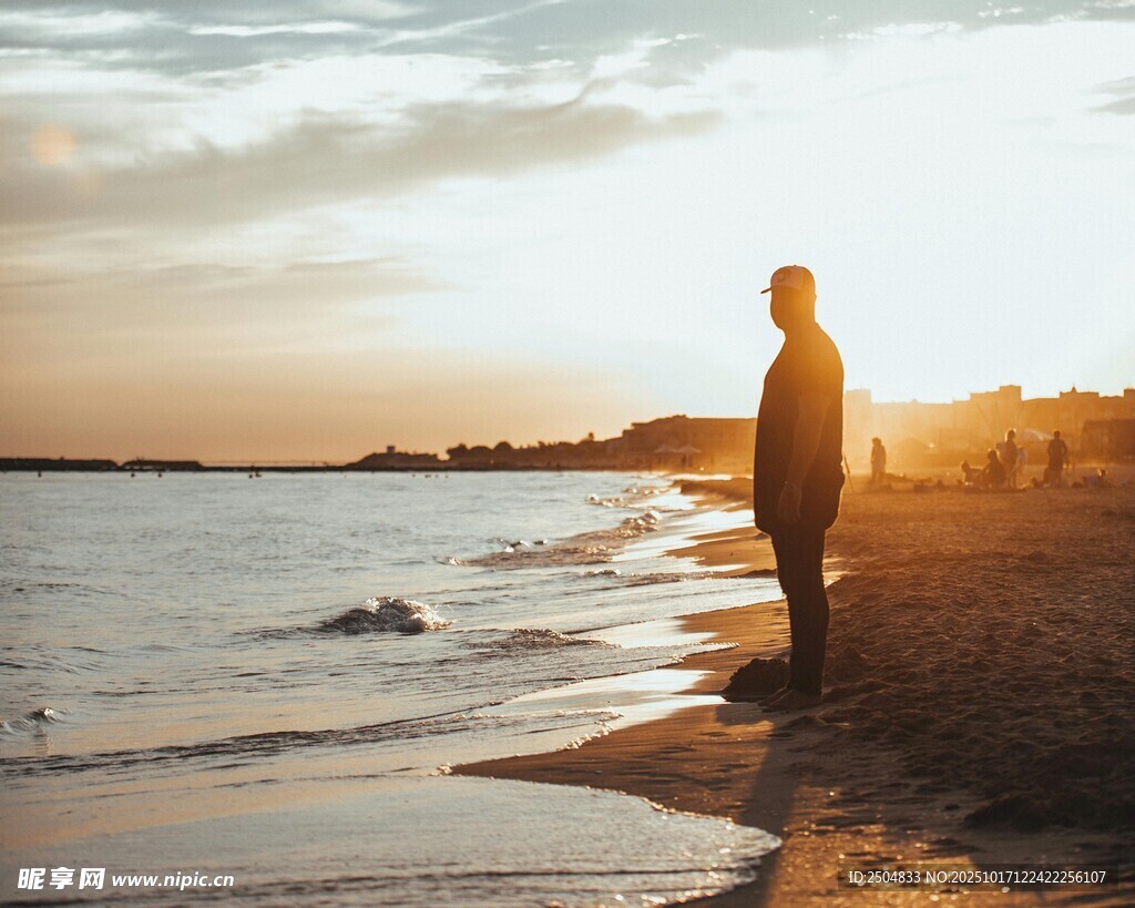 夕阳下海边独自伫立的人