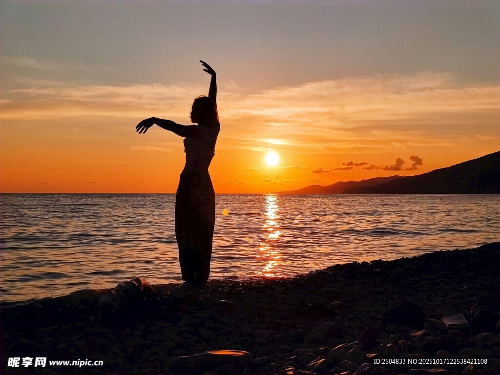 夕阳下海边舞者剪影