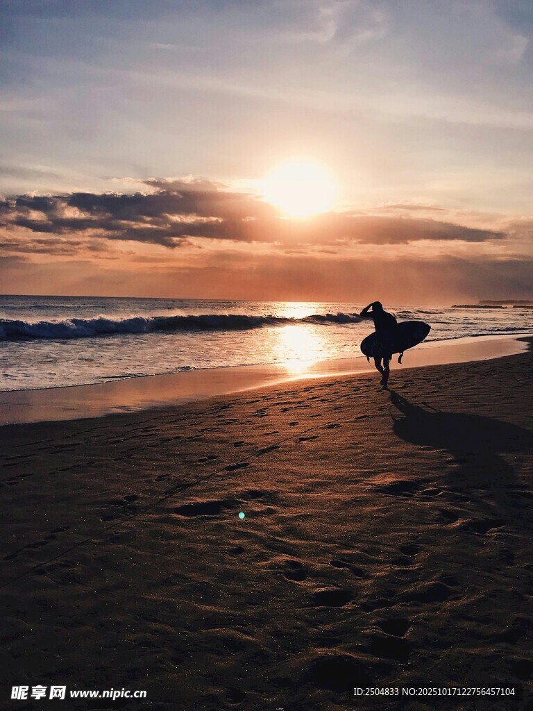 夕阳下的海滩冲浪者